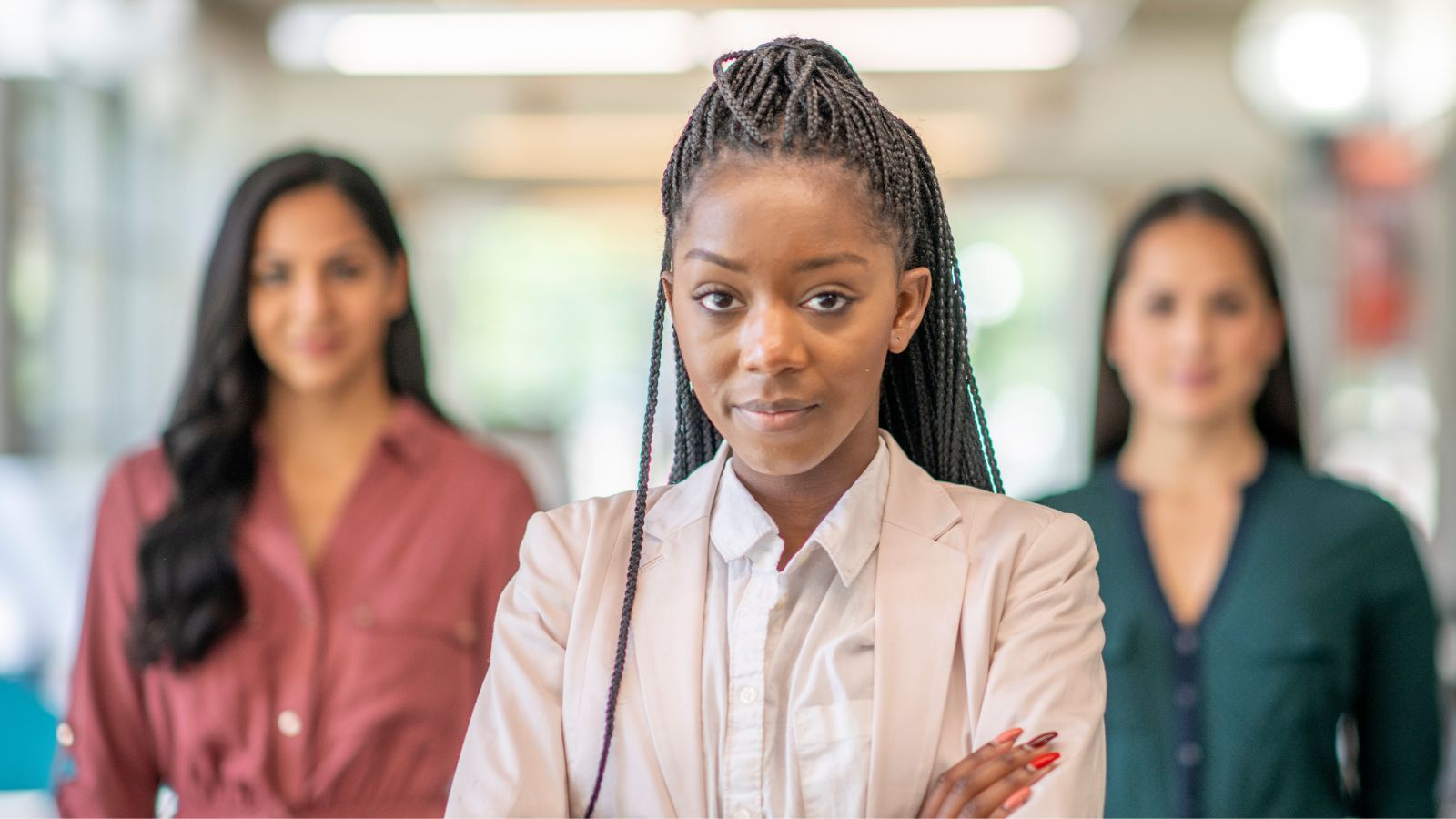 Confident businesswoman standing in front of a diverse team, reflecting Woodhull's commitment as a WBENC-certified business to diversity, inclusion, and empowering women in leadership.