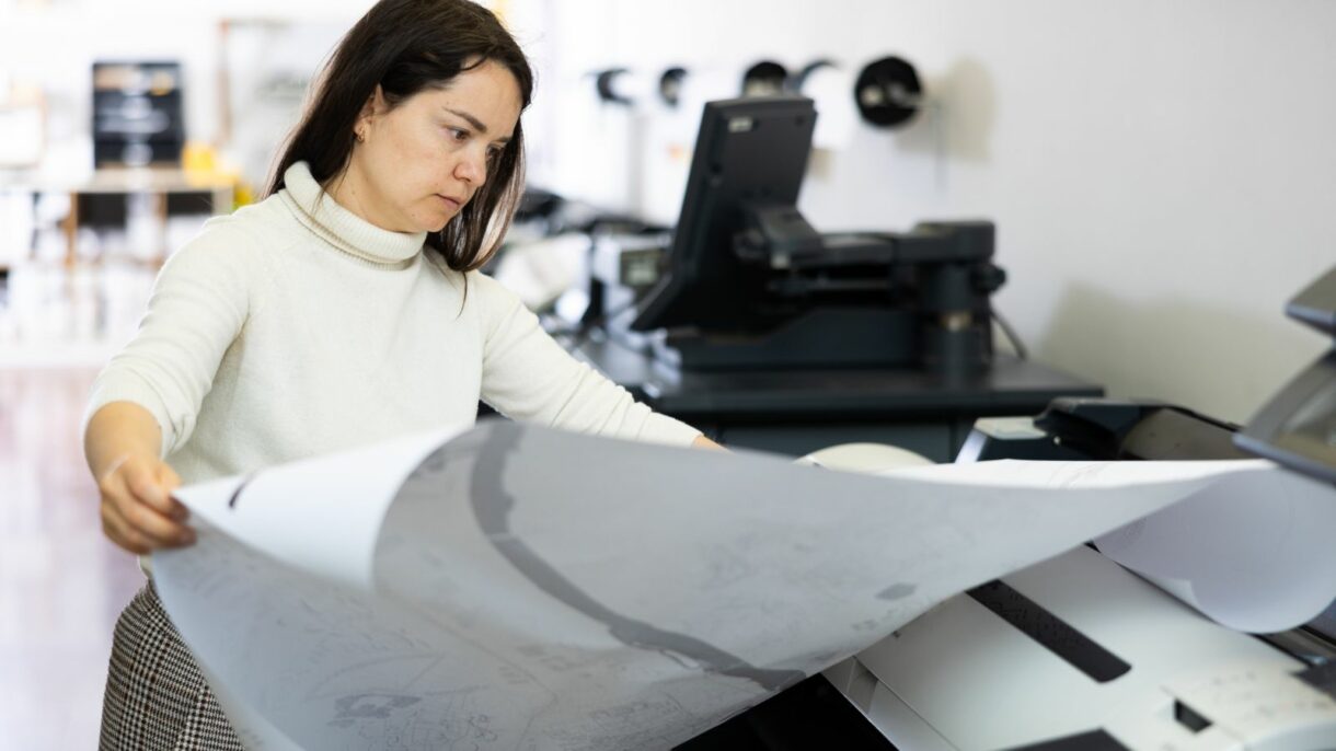 A professional using a large-format printer at Woodhull, LLC, showcasing advanced printing solutions for businesses in Dayton, Cincinnati, and Columbus.